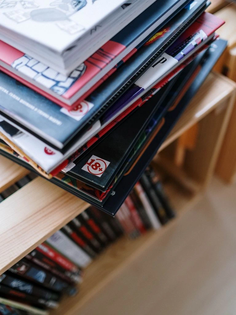 Stack of fresh weekly comic issues on a counter